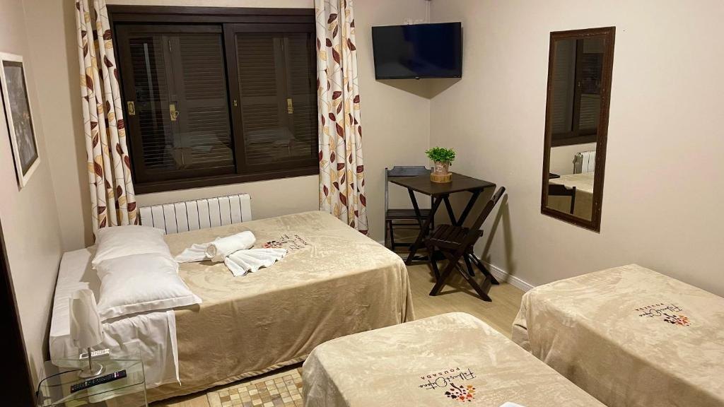 Quarto Família, com uma cama de casal, camas de solteiro, mesa com cadeiras, TV e ar-condicionado