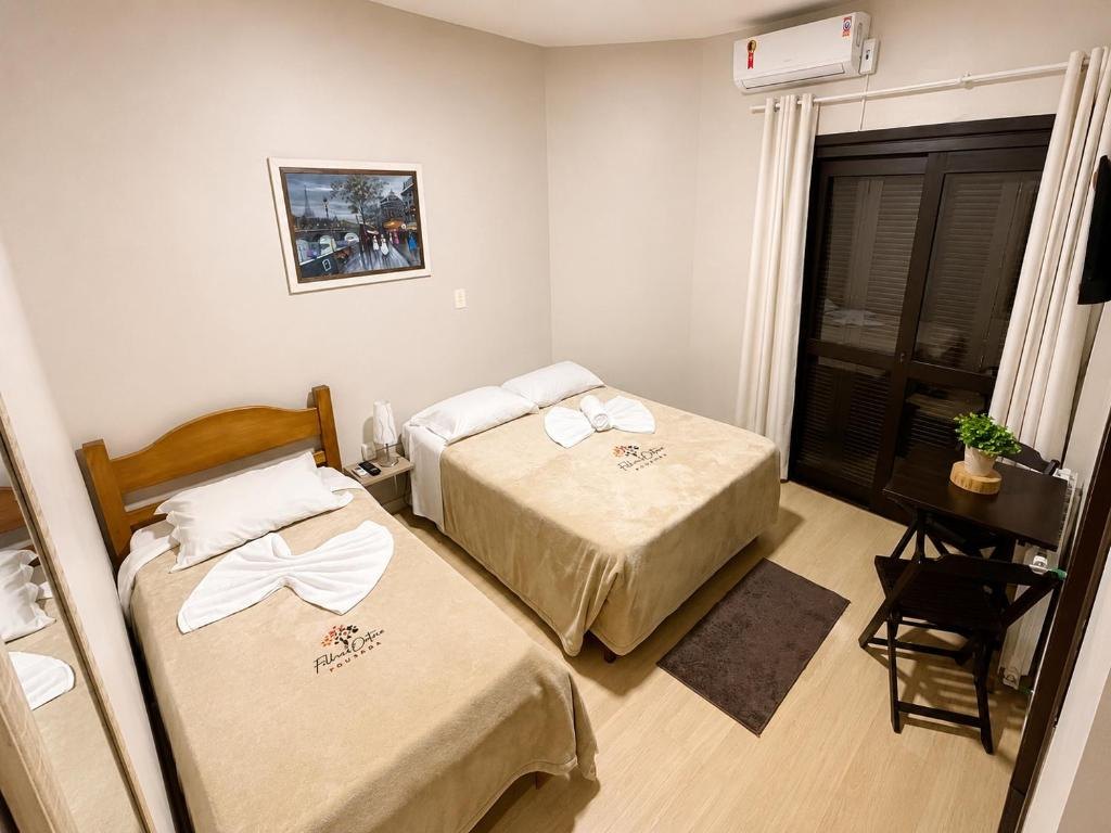 Quarto Triplo da Pousada Folhas de Outono, com cama de casal, cama de solteiro e janela com cortinas